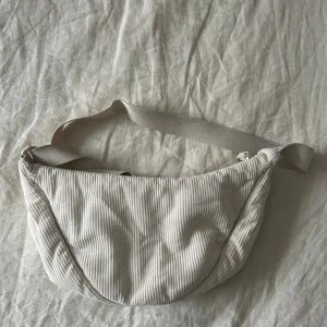 Uniqlo väska - Uniqloväskan i vitt manchestertyg. Jätterymlig och enkel att matcha med. Perfekt för när man reser.  Få 10% rabatt vid köp av två plagg och 20% rabatt vid köp av tre