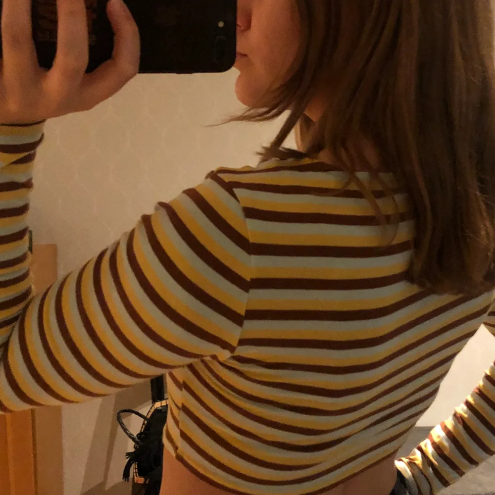 Randig, långärmad tröja med V-shapes från Urban Outfitters 👔Färgerna är ljusblå, brun och gul. Har ej kommit till användning och är i gott skick. Toppar.