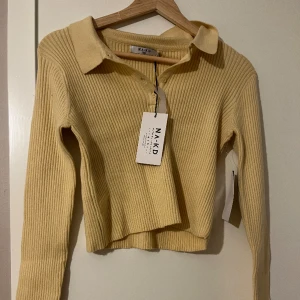 Stickad croptop - Supersöt stickad gul croptop! Aldrig använd, prislappen hänger kvar.