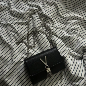 Valentino väska  - Säljer denna valentino väska då den inte kommer till användning längre, den är i fint skick förutom att lite lite av de silvriga försvunnit på V. Skriv om ni vill ha fler bilder 