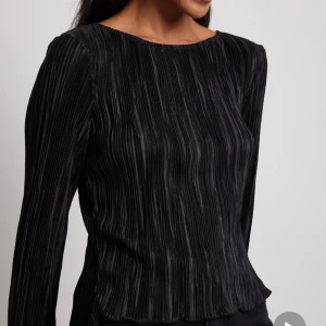 Plisserad topp/ blus från nakd med öppen rygg - Säljer denna fina blus i storlek S, använd 1 gång då den inte kommer till användning! Nyskick