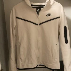 Nike tech fleece - Denna Nike tech fleece är storlek 158-170cm den är jätte bra skick då den inte är använd så många gånger dock har den en liten röd fläck på byxornas ena knä och en svart fläck på ena hoodie ärmen. Denna tech fleece är ganska sällsynt och bra kvalite