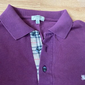 Burberry piké  - En riktigt fet burberry piké i färgen vinröd. Skicket är väldigt bra men det ända som är negativt är att det finns ett väldigt litet hål och ett annat litet hål. Inget man märker. Säljer väldigt billigt pga hål. Pris diskuteras vid snabb affär