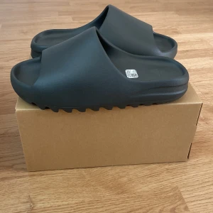 Yeezy Slide Dark Onyx - Säljer nu dessa helt nya och oanvända Yeezy slides. Kvitto finns. Pris går att diskuteras. Har du frågor eller vill ha mer bilder på dem så är det bara att skriva.