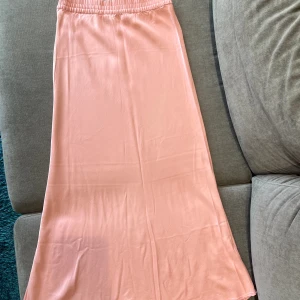 Rosa midikjol - Laxrosa satinkjol! Väldigt skönt och tunt material🤗  Köpt i Polen. Endast använt 1ggr!  (Ursäkta att den inte är struken i bilderna!)