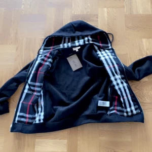 Burberry zip hoodie  - Säljer min svarta burberry hoodie då den är för liten. Storleken är M. Perfekt skick har inte använt nån gång. Lappar finns kvar. Var inte rädda för i höra av er 