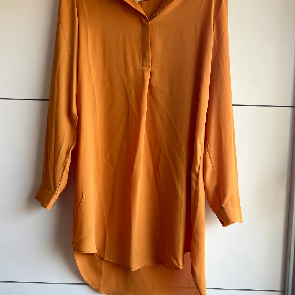 En super fin orange/brun blus som är oanvänd med prislapp på. Storlek 34. Original priset är 380kr säljs för 320kr. Blusar.