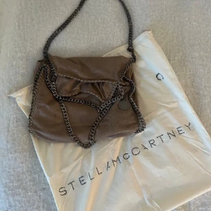 Stella McCartney väska  - Säljer min Stella McCartney väska! Äkta och dustbag medföljer! Färgen är en blandning av brun/beige. Är öppen för prisförslag 