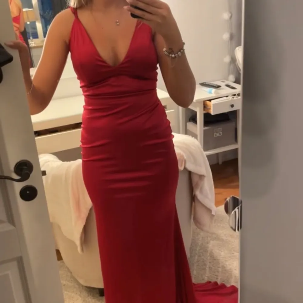 Röd klänning perfekt till balen som sitter jättefint på, endast testad. Den har även som ett släp bakom sig.. Klänningar.