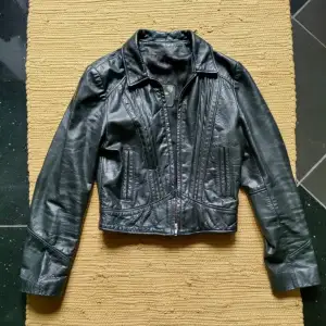 Hej!  Säljer denna fina svarta skinn mc jacka från slutet av 60- talet början på 70-talet.  Jätte cool! Croppad!  Surrey leather   Mått:  Armpit 36  Ärmlängd 56 Collar buttom 48  Axlar 36 
