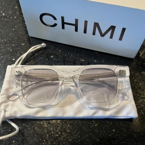 Chimi solglasögon, 04 clear - Väldigt bra skick (det finns dock några små repor). Endast använda ett par gånger. Alla tillbehör ingår! Köpta för 1250kr. Obs modellen/färgen heter clear
