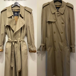 Burberry Trenchcoat  - Vintage Burberry trenchcoat med bälte. Klasssk, jättefin och i väldigt gott skick.  Läderspännerna är välbevarade men visar lite ålderstecken. Överlag väldigt gott skick men har några få knappt märkbara fläckar.  Inköpt på Vestiaire 2022