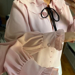 Rosa blus  - Med volang och knytning fram i ljusrosa!