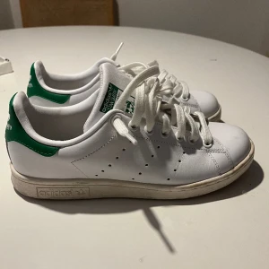 Adidas Stan Smith - Vita & gröna adidas stan smith i storlek 38. Använda några gånger men de är lite för små för mig. Sulan är lite smutsig men det går enkelt att torka av. 