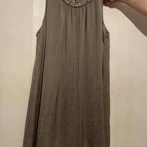 Snygg brun klänning med pärlor. Strl L - Se bilder :)