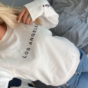 Vit tröja från Hollister - Säljer en snygg vit tröja från Hollister med texten 'Hollister Los Angeles' på framsidan.