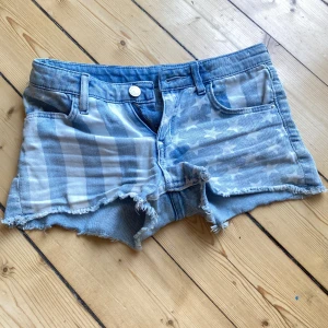 Blå jeansshorts från &Denim - Säljer ett par snygga blå jeansshorts från &Denim. De har ett coolt rutigt och stjärnmönster på framsidan och är slitna med fransar vid benen. Perfekta för sommaren! 🩳💙