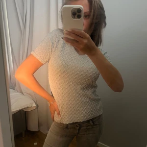 MÖNSTRAD TOPP - Säljer en vit kortärmad topp från Body i storlek L/XL. Toppen har en texturerad yta som ger den en unik look. Perfekt för både vardag och fest! Helt oanvänd❤️‍🔥