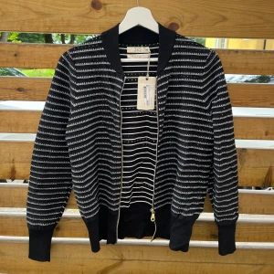 Svart och vit randig jacka från 365 - Säljer en snygg svart och vit randig Cardigan från märket 365. Den har en dragkedja framtill och är långärmad. Den är perfekt för både vår och höst och har en normal passform. Materialet känns högkvalitativt!  Nypris 599 och prislappen hänger kvar!