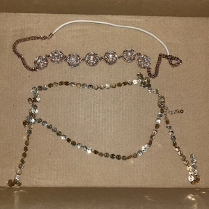 Två glittriga halsband - Säljer två superglittriga håraccessoarer! Det ena har stora, runda pärlor med glittriga stenar och en kedja i guld. Det andra är en lättare kedja med små, runda paljetter i  guld. Perfekta för fest eller nyår! ✨