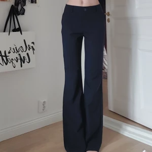 Utsvängda kostymbyxor - Ett par jättefina högmidjade mörkblåa kostymbyxor i bra skick, fickor både fram och bak. 