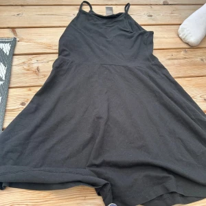 Svart klänning från Lindex - Säljer en svart klänning från Lindex i storlek 134/140. Klänningen är ärmlös och har en enkel, stilren design. Perfekt för både vardag och fest!