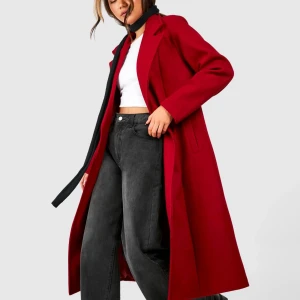 Röd kappa från Boohoo - Säljer en snygg röd kappa från Boohoo. Den är lång och har en klassisk design med knappar framtill. Perfekt för höst och vinter. Jackan är i nyskick och har en normal passform. Den är tillverkad i ett mjukt och bekvämt material som håller dig varm under kyliga dagar. Passar både till vardags och fest!