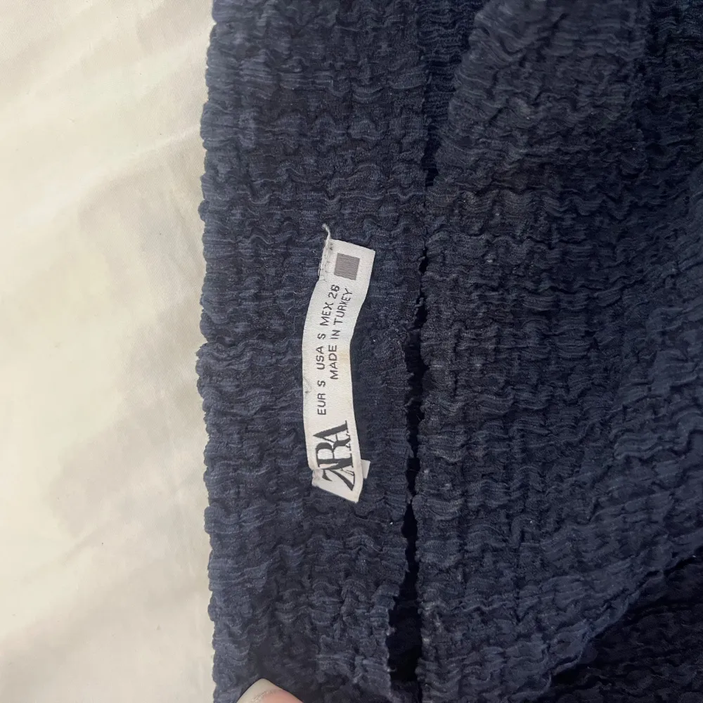 Toppen är kortärmad och har en texturerad yta som ger den en unik look. Den är något croppad och har en tight passform. Tryck köp nu!😍. Yläosat.
