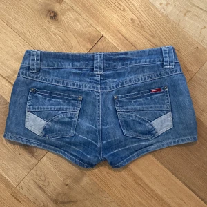 Blå jeansshorts från Only - Säljer ett par snygga blå jeansshorts från Only. De är lågmidjade och har en tight passform. Shortsen har två fickor bak och två fram, samt en knapp och dragkedja framtill. Perfekta för sommaren! 🌞