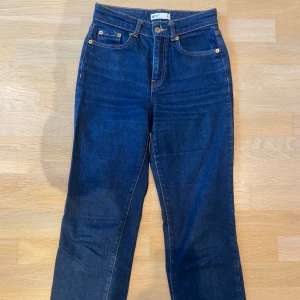 Mörkblå jeans från Gina Tricot - Mörkblå jeans från Gina Tricot. Åtsittande midja, smått utsvänga. Storlek 34.