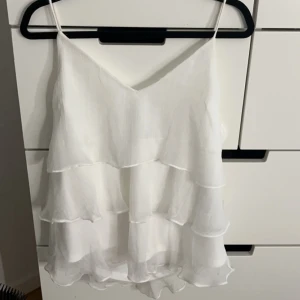 Volangtopp - Säljer denna så söta vita volangtopp från vero Moda i storlek xs! Endast använd 2-3 gånger och är i bra skick!🤍🤍kan även tänka mig byta mot något annat