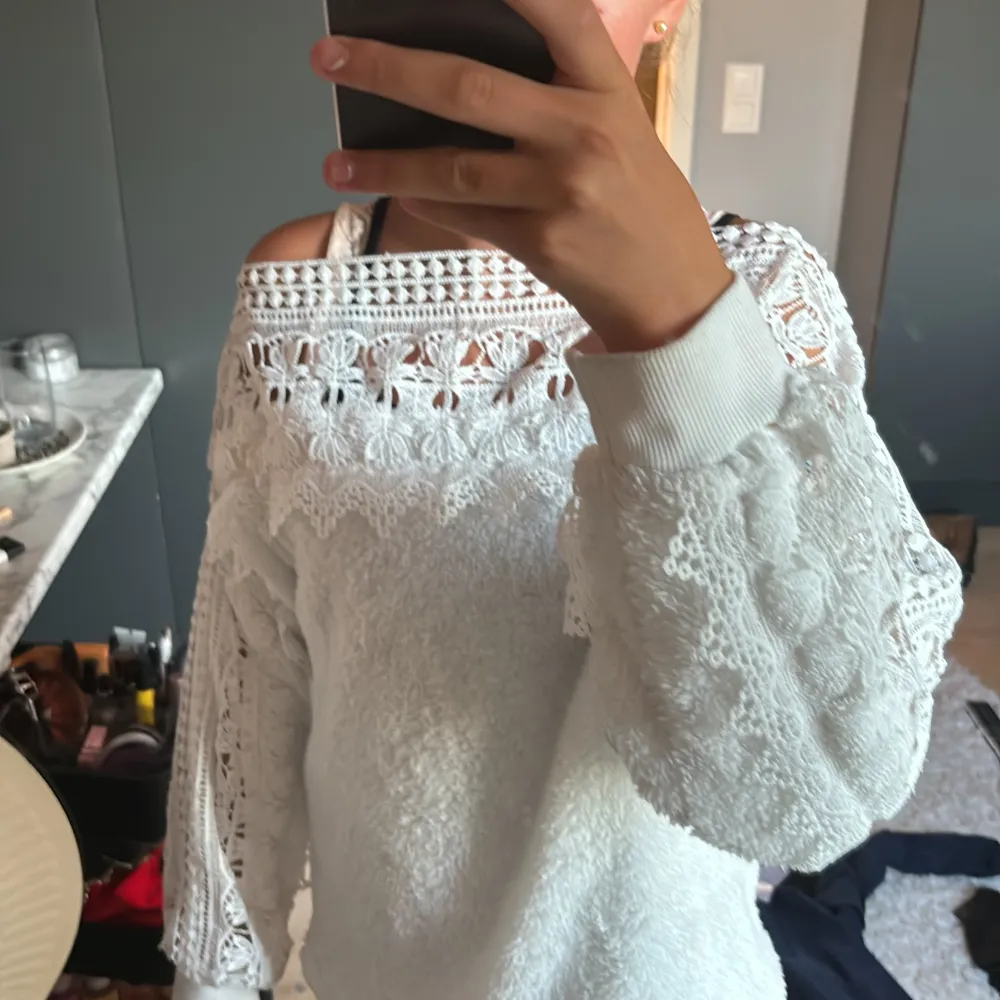 Säljer en superfin vit off-shoulder tröja med spetsdetaljer. Tröjan är långärmad och har en lös passform. Den är perfekt för vår och sommar och kan användas både till vardags och fest. Materialet är mjukt och bekvämt, och spetsen ger en romantisk touch. Passar perfekt till jeans eller kjol!. Tröjor & Koftor.