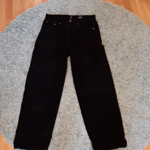 Svarta manchesterbyxor från H&M - Säljer ett par svarta manchesterbyxor från H&M i storlek 30. Byxorna har en loose fit passform och är perfekta för en avslappnad stil. De är lite sönder i slutet av byxorna men jag skulle nog säga att skick är 7/10
