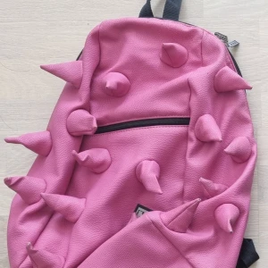 Madpax rosa taggig ryggsäck - Stor ryggsäck: ca 40×28 cm. Framficka: ca 20×22 cm. Har använts några år och har slitage, men påverkar inte användningen. Annars i bra skick. Nypris: 700 kr. För mer info, skriv gärna✨️  