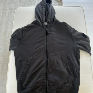 Grå stone island hoodie  - Grå stone island zip hoodie i 9/10 skick. Köpt på NK i Göteborg och kvitto finns