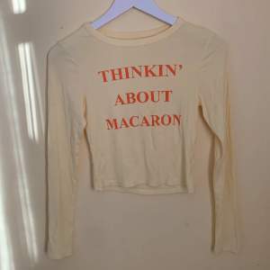 Långärmad gul t-shirt med trycket ”thinkin’ about macaron” i stretchigt material.