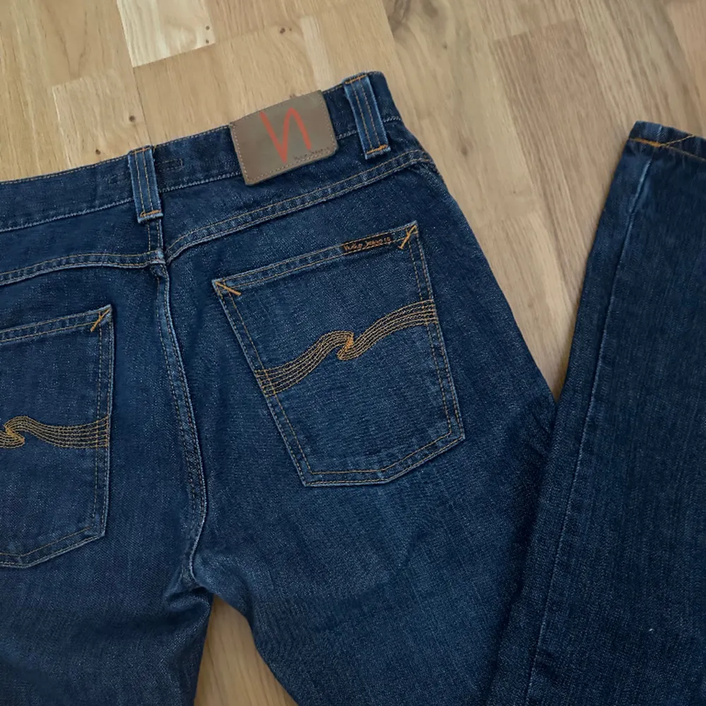 säljer dessa jeans från nudie jeans med orangea detaljer i herrmodell. nypris 1400. dem är i väldigt bra skick. innerbenslängden är ca 79-80 cm och midjemåttet rakt över 41 cm. skriv vid frågor eller för fler bilder! . Jeans & Byxor.