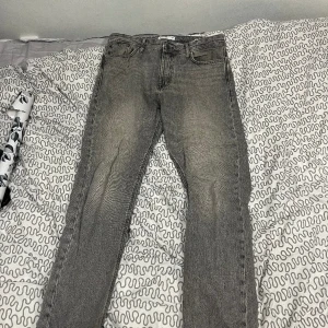 Gråa Jack&Jones jeans - Säljer dessa snygga jack and jones jeans (loose/chris) då de inte kommer till användning längre. Använt de en del så de har börjat gå upp lite längst ner på byxorna och har nån liten liten fläck någonstans men annars är de bra. Skriv för fler bilder.