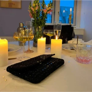 Glittrig liten väska  - Svart väska med glitter från Beck Söndergaard (Sevilla Paradi Bag). Går att använda både som crossbodyväska, axelväska samt kuvertväsk. Slutsåld samt aldrig använd. Köpt för 549kr - Säljer för 300kr