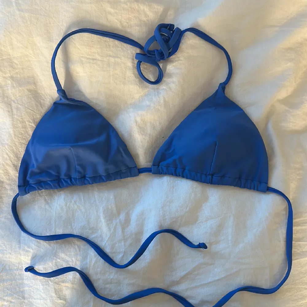 Superfin blå bikiniöverdel som säljs pga för liten storlek. Den är något solblekt på framsidan men är fortfarande i väldigt gott skick och snygg färg. Skulle säga att den passar en xs/s. Övrigt.