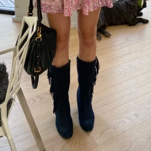 Höga boots med fransar - Boots med klackar som har fransar på sidorna i en marinblå färg!! Mycket bra skick! De är i mocka