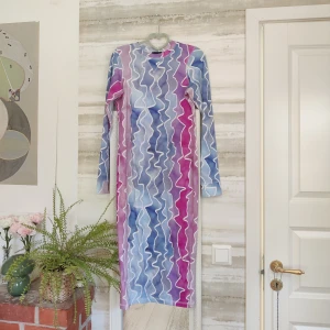 Bodycon midiklänning - Rosa, vit, lila, blå mönstrad klänning från Asos från typ 10 år sen, oanvänd. Jättefin! Sitter tajt, är stretchig. På mig som är 165cm går den nedanför knäna. 