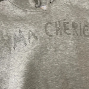 Grå hoodie med ”ma cherie” glittertext - Stockholmstil