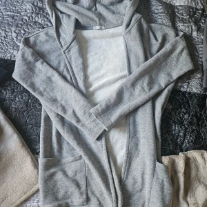 Grå hoodie från Bershka - En bekväm grå hoodie från Bershka med långa ärmar och två framfickor. Hoodien har en enkel design och är tillverkad i ett mjukt material.