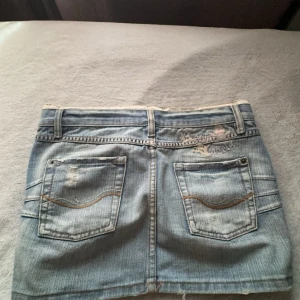 Jeanskjol - Säljer den här lågmidjade unika jeanskjolen i stl S. Vid intresse eller funderingar, kontakta mig. Annars använd gärna köp nu funktionen💞 349:-