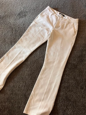Vita lågmidjade kostymbyxor 🤍 - Vita lågmidjade kostymbyxor från Bikbok med slits. Jättefina men har ett litet märke på baksidan. Stl 38 men skulle säga 36 🤍