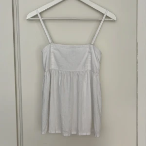 Bik Bok fin vit topp XS - Fin vit Bik Bok topp med tunna, justerbara axelband. De kan också tas av för strapless topp. Toppskick, knappt använd. Strl XS. Linnemix 55% linne, 45% viskos.