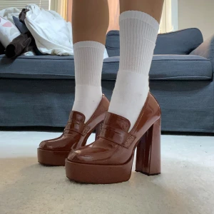 Nya Högklackade Bruna Loafers - Dessa par Bruna Högklackade Loafers har stått i mitt rum som dekoration och är ej använda. Klacken är 13 CM och plattformen är 3,5CM