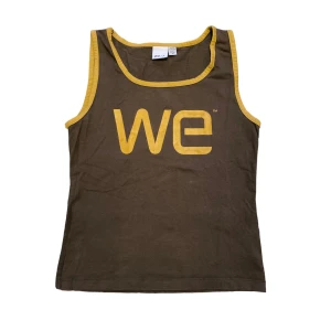 Brunt linne med tryck - Coolt brunt sommarlinne med gult tryck🤩🤩 Står M i lappen men skulle säga att den sitter mer som en S. Skriv privat vid intresse eller frågor🫶🏻🫶🏻