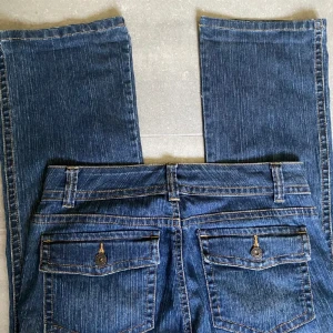 Vintage y2k lågmidjade bootcut jeans med fickor - Midja:38/39cm. Innerben: 79cm. Storlek 6 vilket motsvarar en storlek S ungefär. För små på mig så tyvär har jag ingen bild med dom på mig. Vintage i fint skick. Så coola. Tryck gärna på köp nu🫶🫶 